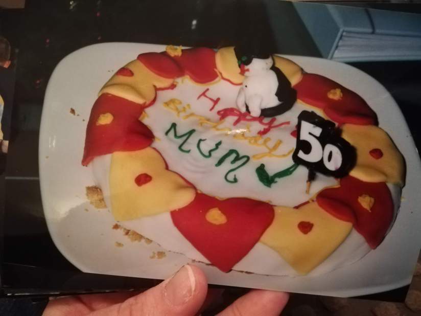 Photo of the cake I made for my Mum's 50th. It's supposed to be a white cake with red and yellow hearts and a marzipan figure of a black and white cat on top. Trust me when I say it does not look like that. It's a complete fucking mess.