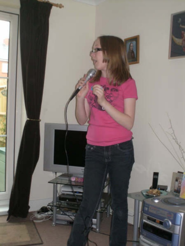 Me in a pink t-shirt singing karaoke