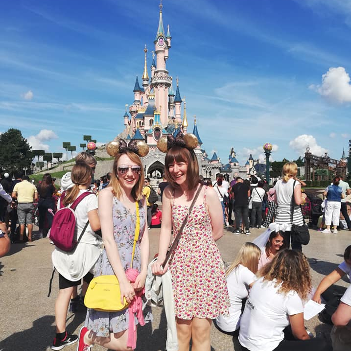 Lillie and I standing in front of Disneyland's iconic castle, wearing our Mickey Mouse ears