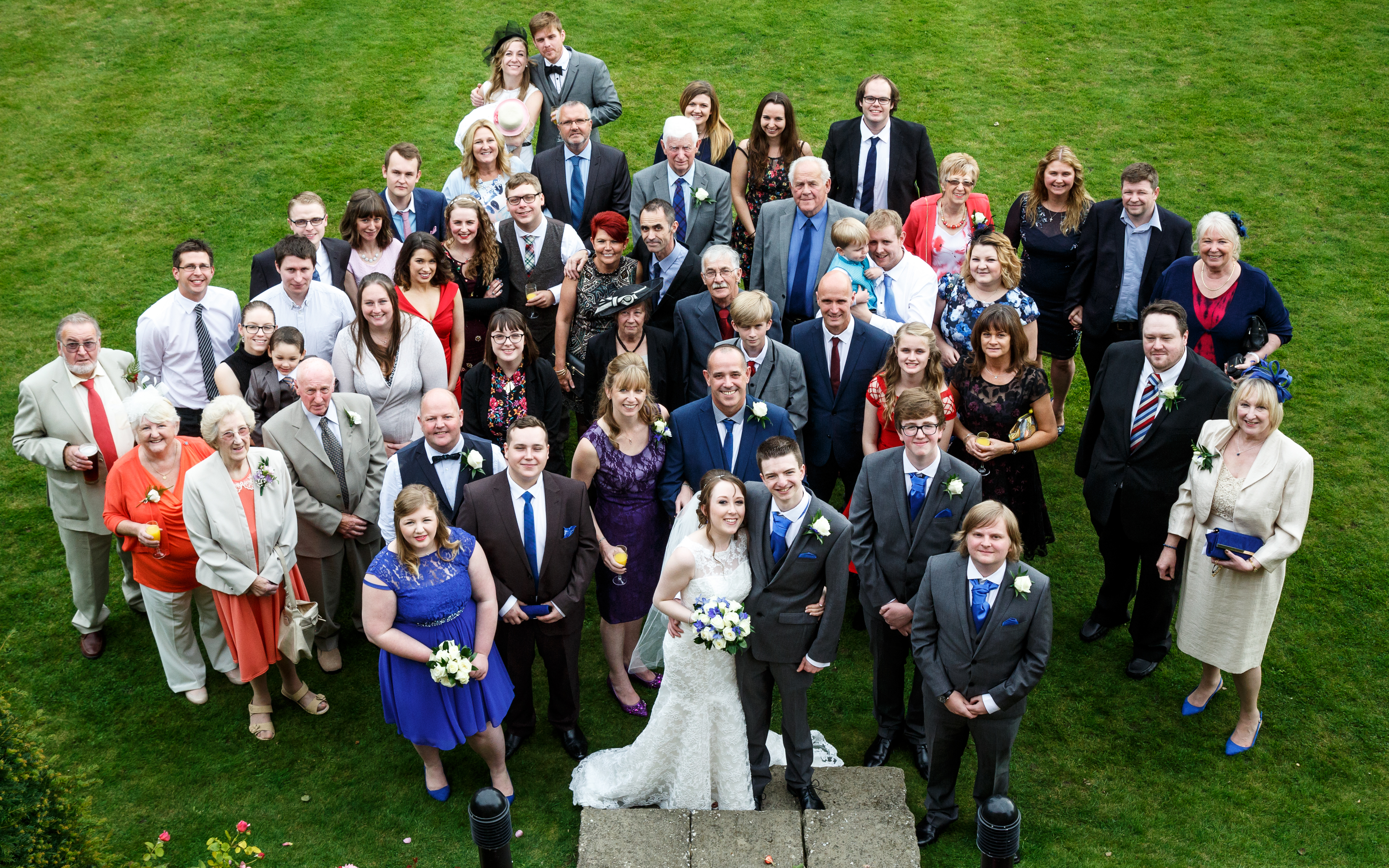 Birds' eye photo of Liam and I stood with all our wedding guests