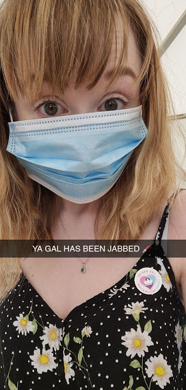 A Snapchat I sent a few minutes after my vaccine. I'm wearing a mask that's way too big for my face so you can barely make out my expression, but I'm looking wide eyed and proudly wearing my sticker that says "I've had my Covid vaccination." In the middle of the picture I've captioned it "YA GAL HAS BEEN JABBED."