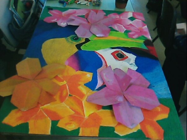 My exam piece for GCSE art - a picture of a toucan and a puffin in bright colours, surrounded by a combination of 3D flowers.