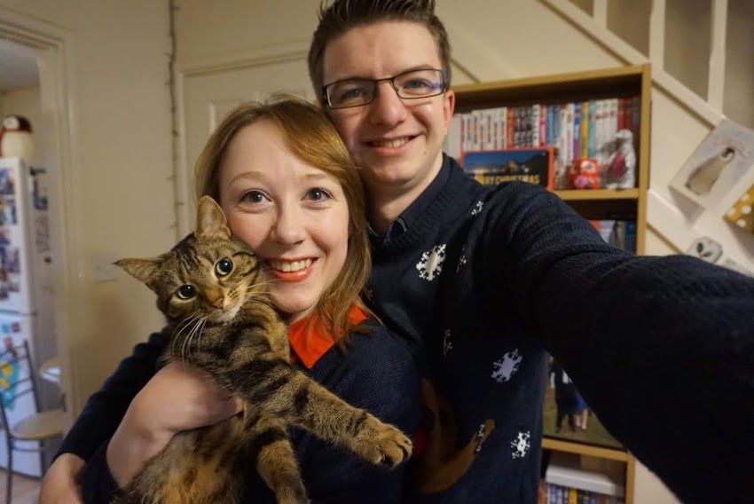 Christmas 2016 - Me, Liam, and Tilly. Liam and I are both smiling and dressed in Christmas jumpers, while Tilly is posing and looking at the camera.
