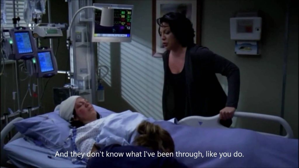 Callie's ghost stands over her unconscious body lying in a hospital bed.