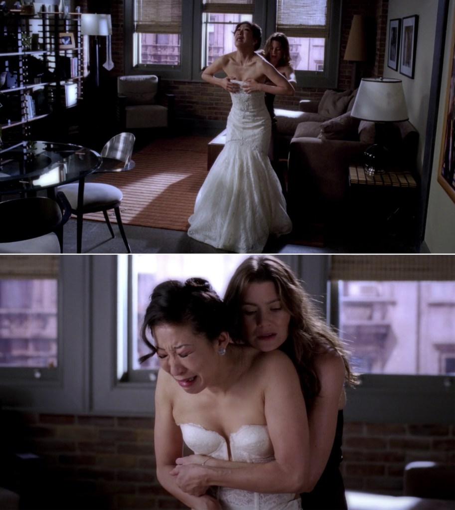 Cristina cries as she tries to get out of her wedding dress while Meredith hugs her from behind.