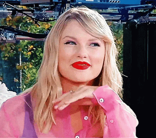 Gif of Taylor Swift smiling and flicking her hair