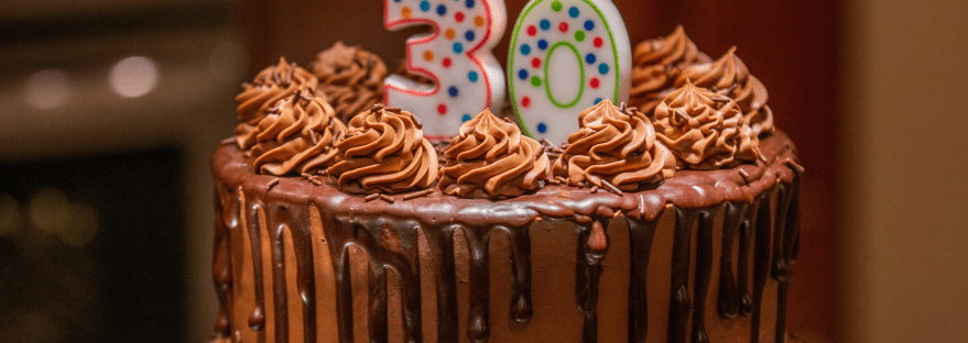 A chocolate cake with a '30' candle lit on top of it